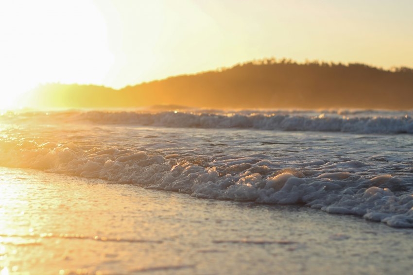  A praia do Campeche, em Florianópolis, brilha sob o sol abrasador, convidando os visitantes a se refrescarem nas águas refrescantes do oceano